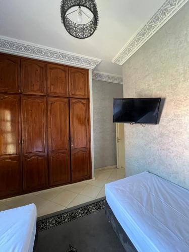 a bedroom with a bed and a flat screen tv at A room in Guéliz only for ladies in Marrakesh