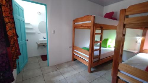 a room with two bunk beds and a bathroom at Casajungla Hostel in Jacó