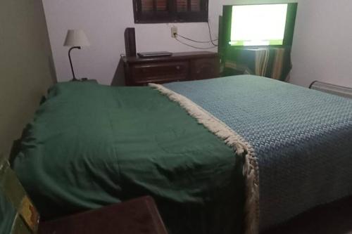 een slaapkamer met een bed met een groene deken bij finca de barcena, country house in Tumbaya