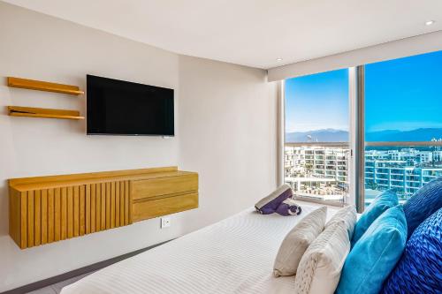 a bedroom with a bed and a tv and a window at Ocean Vista Oasis at Maritima Playa in Bucerías