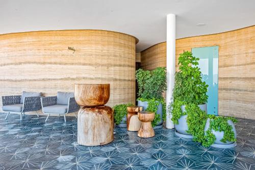 a lobby with wooden logs and chairs and plants at Ocean Vista Oasis at Maritima Playa in Bucerías
