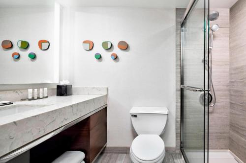 a bathroom with a toilet and a sink and a shower at New York LaGuardia Airport Marriott in Queens