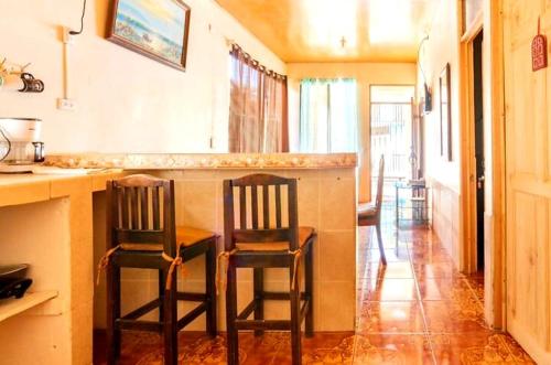 - deux chaises assises au bar de la cuisine dans l'établissement Apartamentos Morpho CR 2, à Quepos