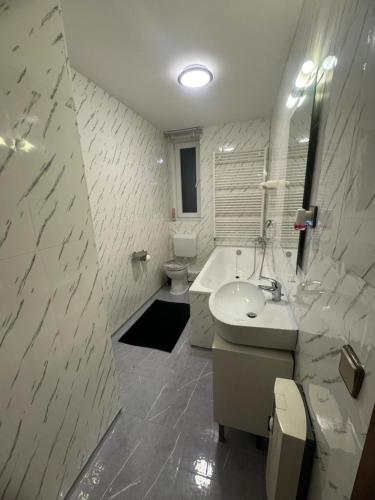 a white bathroom with a sink and a toilet at HomeStay in Bochum