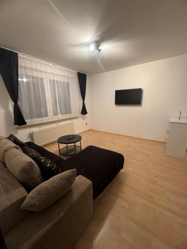 uma sala de estar com um sofá e uma televisão de ecrã plano em HomeStay em Bochum