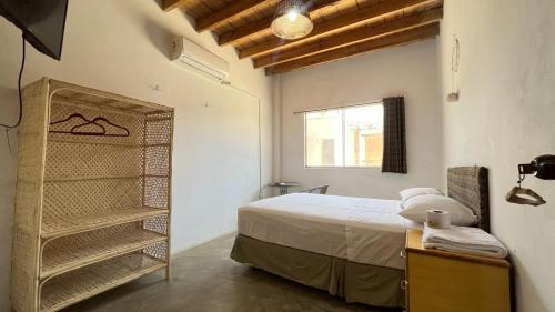 a bedroom with a bed and a window and a shelf at Hospedaje & Casa Playa AURORA in Zorritos