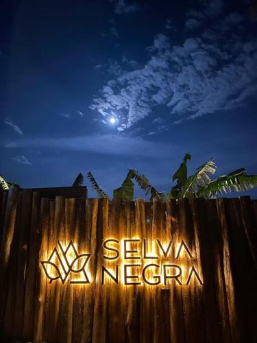 a sign on a wooden fence with the moon in the background at Selva Negra Cabins in Pereira