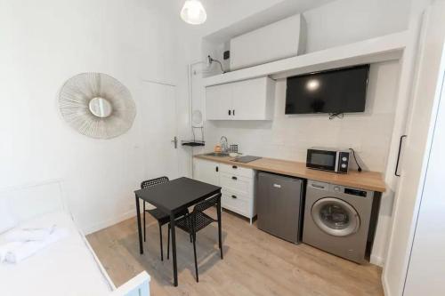 une petite cuisine avec une table et un lave-linge. dans l'établissement Cosy studio à Asnières, à Asnières-sur-Seine