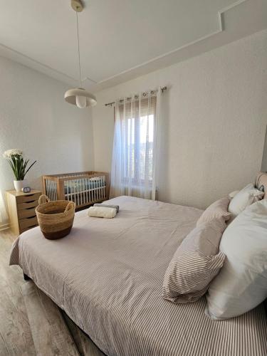 Un dormitorio con una cama grande con una cesta. en La Maison Richard, en Thizy-les-Bourgs