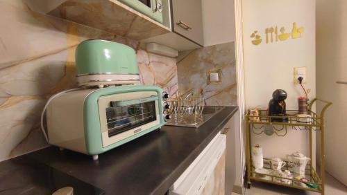 a kitchen with a green appliance on a counter at ESCAL'HOME , appart design au pied de l'aéroport,parkings in Blagnac