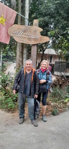 a man and a woman standing in front of a sign at Hill House in Mai Chau