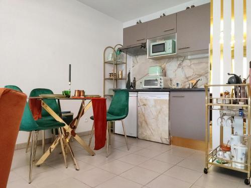 uma cozinha com uma mesa e cadeiras verdes em ESCAL'HOME , appart design au pied de l'aéroport,parkings em Blagnac