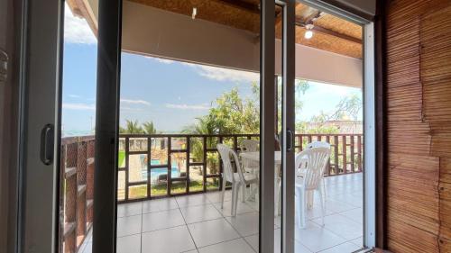 a glass door leading to a balcony with a table and chairs at Hospedaje & Casa Playa AURORA in Zorritos