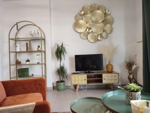 a living room with a television and a table at ESCAL'HOME , appart design au pied de l'aéroport,parkings in Blagnac