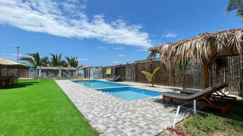 a house with a swimming pool and a grass yard at Hospedaje & Casa Playa AURORA in Zorritos