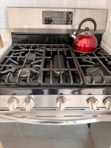 a red tea kettle sitting on top of a stove at Exclusive fully equipped Condo with great pool in Jacó