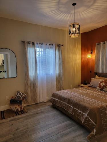 1 dormitorio con cama y lámpara de araña en El susurro de las mariposas en Jarabacoa