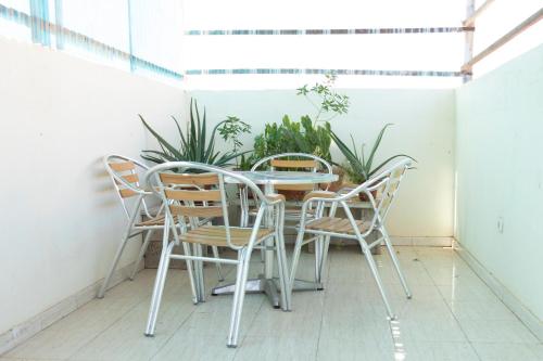 einen Tisch und Stühle auf einem Balkon mit Pflanzen in der Unterkunft Cozy studio apt in Terra Branca with WIFI - LCGR in Praia