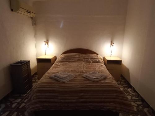 a bedroom with a bed with two lamps on it at La Familia in General Roca