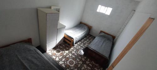 a small room with two beds and a dresser at La Familia in General Roca