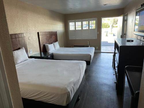 a hotel room with two beds and a kitchen at The Dixie Orange County in Stanton