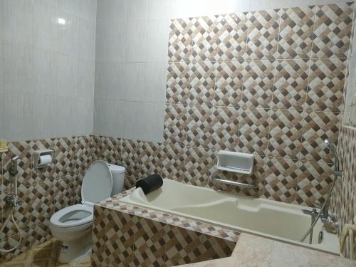 a bathroom with a toilet and a bath tub at Vila Princess,Sentul 4br, private pool, tenis meja, mini billiard, Home theater Karaoke, Ayunan besar,BBQ, 08satu3 80satu6 4satu5satu in Bogor