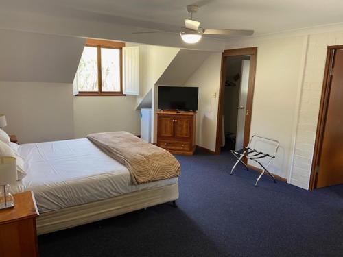 a bedroom with a bed and a flat screen tv at Girraween Country Inn in Ballandean