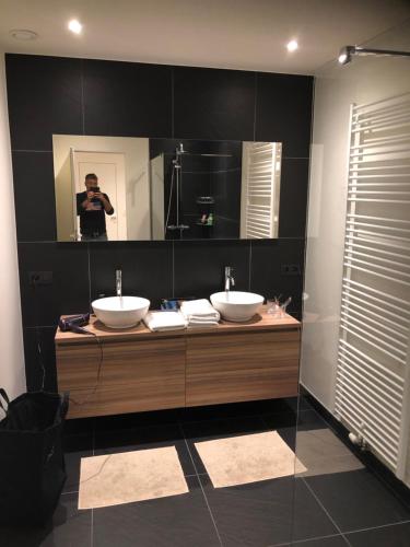 亞貝克的住宿－Maison XV，一个人拍着一个浴室的图片,浴室里有两个水槽