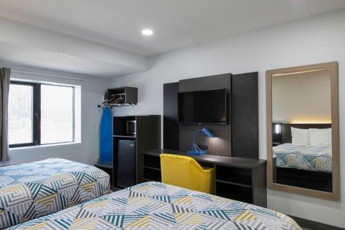 ein Hotelzimmer mit 2 Betten, einem Schreibtisch und einem Spiegel in der Unterkunft Motel 6-Atlanta, GA - Downtown in Atlanta