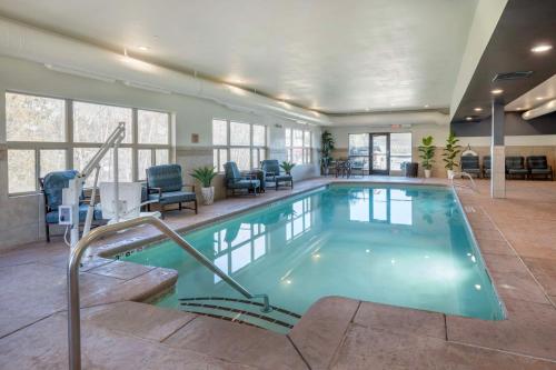 a large swimming pool in a large room with chairs at Best Western Plus Ponderay Mountain Lodge Sandpoint in Ponderay