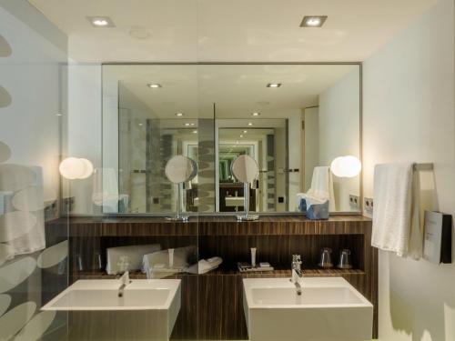 Un baño con dos lavabos y un espejo grande. en Inspira Liberdade Boutique Hotel, en Lisboa