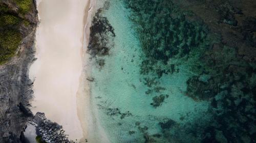 an overhead view of a beach and the ocean at Umana Bali, LXR Hotels & Resorts in Uluwatu