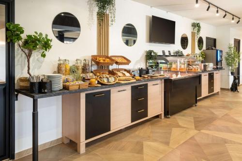a buffet line with bread and pastries on it at Sure Hotel by Best Western Rouvignies Valenciennes in Valenciennes