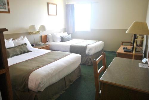 um quarto de hotel com duas camas e uma mesa em Wheatland Hotel em Strathmore