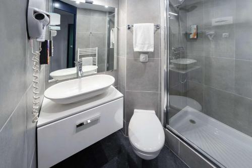 y baño con lavabo, aseo y ducha. en Sure Hotel by Bestwestern Rouvignies Valenciennes en Valenciennes