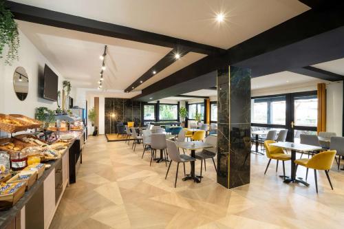 un restaurant avec des tables et des chaises et une cafétéria dans l'établissement Sure Hotel by Best Western Rouvignies Valenciennes, à Valenciennes