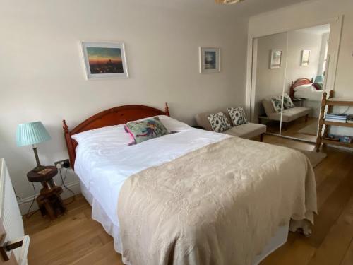 a bedroom with a white bed and a living room at Bright Suite in Whitstable