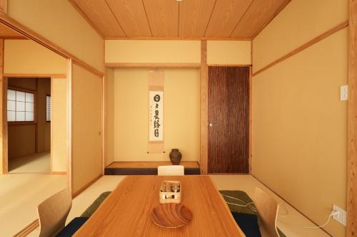 Pokój z drewnianym stołem i krzesłami w obiekcie RIKKA BABA ICHI w mieście Takayama