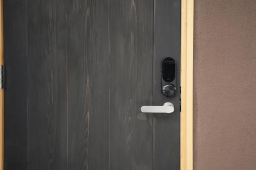 a black door with a white handle on it at RIKKA BABA ICHI in Takayama