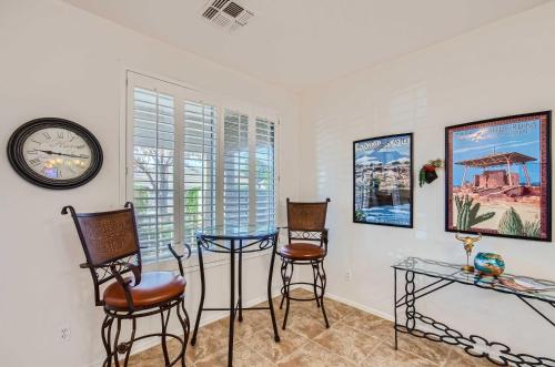 a room with two chairs and a table and a clock at Heated Pool, Gas Grill and Yard Phoenix Retreat! in Avondale