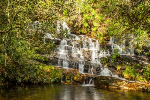 a waterfall in the jungle on a river at Pousada Sete Quedas in Carrancas