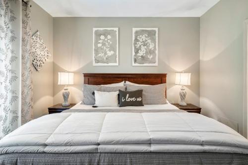 1 dormitorio con 1 cama blanca grande y 2 lámparas en Luxury Condo, Sleeps 6, 3.2 Miles to Dollywood en Pigeon Forge