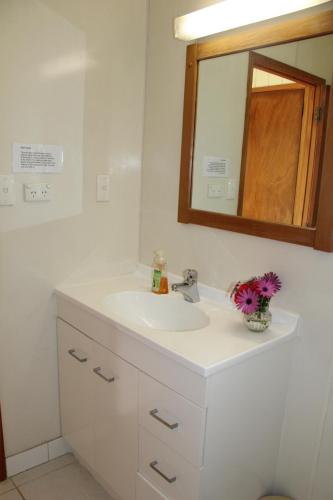 bagno con lavandino bianco e specchio di Saints Apartments a Burnt Pine