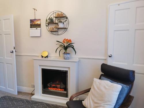a living room with a fireplace and a chair at Entire house Sheffield s10booking in Stannington