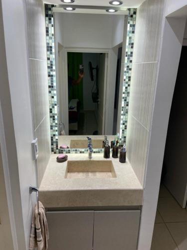 Un baño con lavabo y un espejo grande. en Deptos John Vargas, en Guaymallén