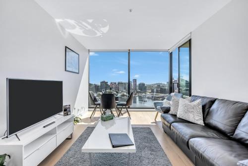 メルボルンにあるMelbourne Lifestyle Apartments - Best Views on Collinsのソファと薄型テレビのあるリビングルーム