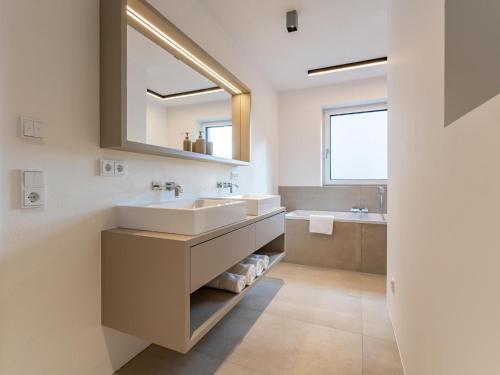 łazienka z umywalką i lustrem w obiekcie Ferienwohnung Emilia w mieście Niedernsill