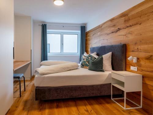 sypialnia z dużym łóżkiem i drewnianą ścianą w obiekcie Ferienwohnung Emilia w mieście Niedernsill