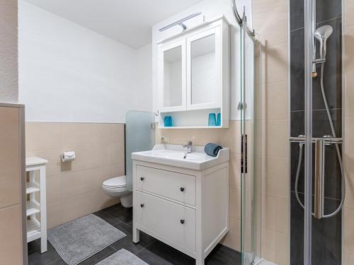 La salle de bains est pourvue d'un lavabo blanc et d'une douche. dans l'établissement Conny, à Maria Alm