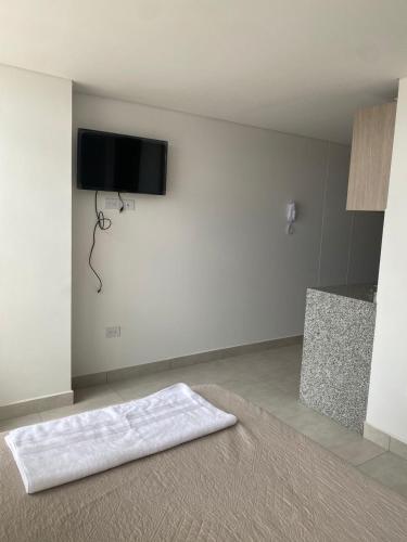 Dieses weiße Zimmer verfügt über einen Flachbild-TV an der Wand. in der Unterkunft Excelente nuevo Apartaestudio in Popayan